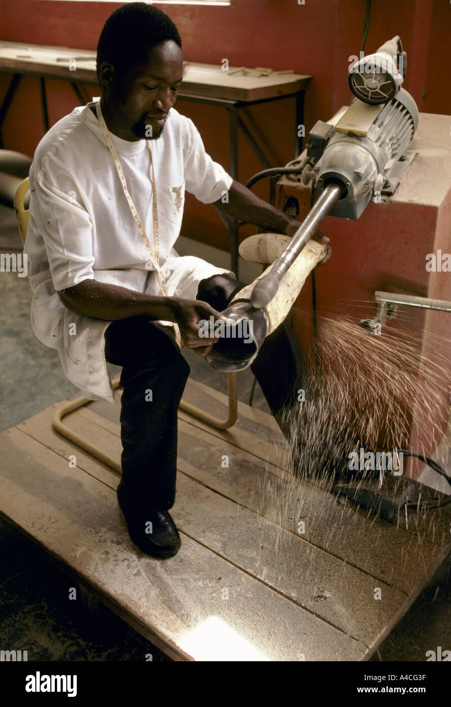 Operatore sanitario false arti mediante macchina utensile da banco tornio croce rossa clinica per persone amputate Mozambico Foto Stock