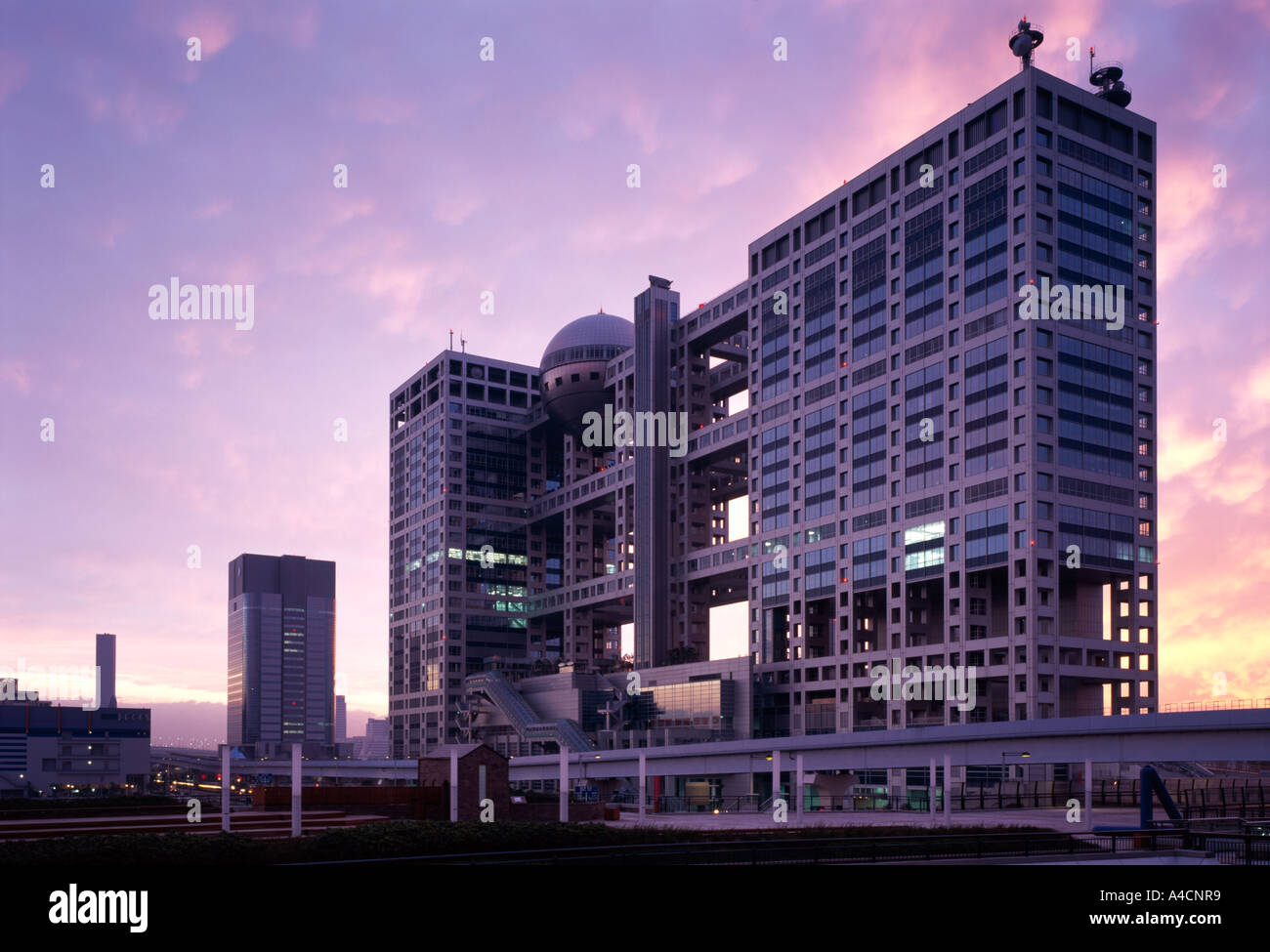 Fuji-Sankei Communications Group Headquarters Building, Odaiba, presso Tokyo, 1996. Anteriore/laterale vista in elevazione presa al tramonto. Foto Stock