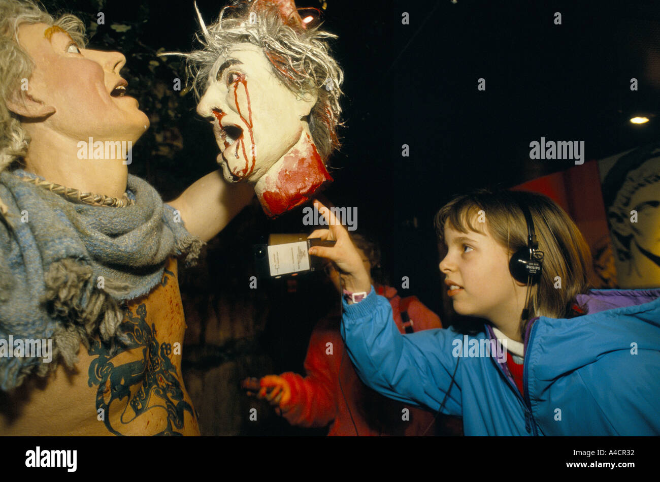 I bambini guardando il display del druido rituali, uomo con una testa di spurgo. Le Bianche scogliere di esperienza, Dover, Inghilterra, marzo 1994 Foto Stock