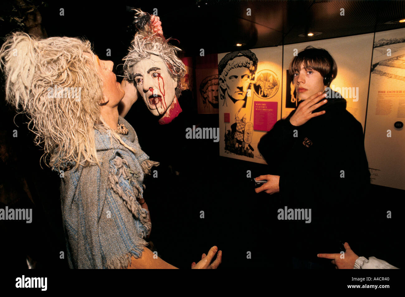 Bambini ascolto alla guida di auido con cuffie, guardando il modello di display del druido rituali. Le Bianche scogliere di esperienza, Dover, MA Foto Stock