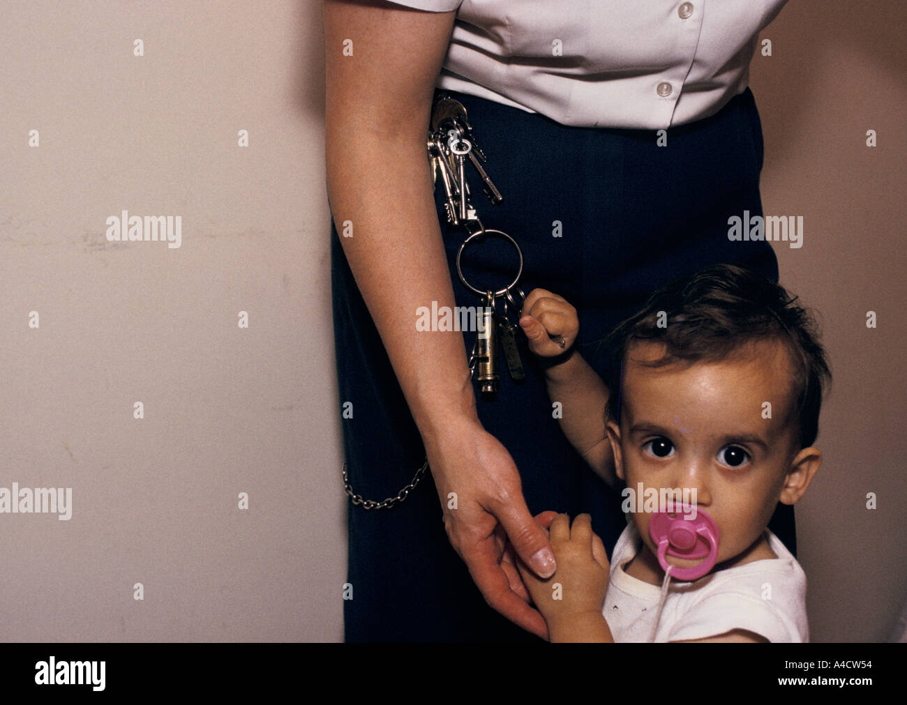 Il bambino di un prigioniero gioca con le chiavi di una prigione warden. Foto Stock