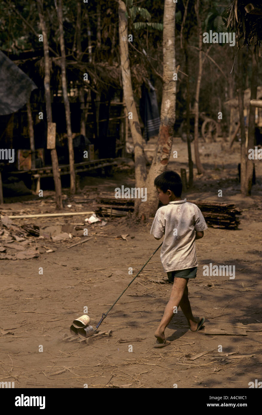 Un bambino gioca con un giocattolo carrello a Lei Kwi camp per famiglie di etnia karen in fuga esercito birmano offensive, Karen Stato, Birmania, Marzo 1992 Foto Stock