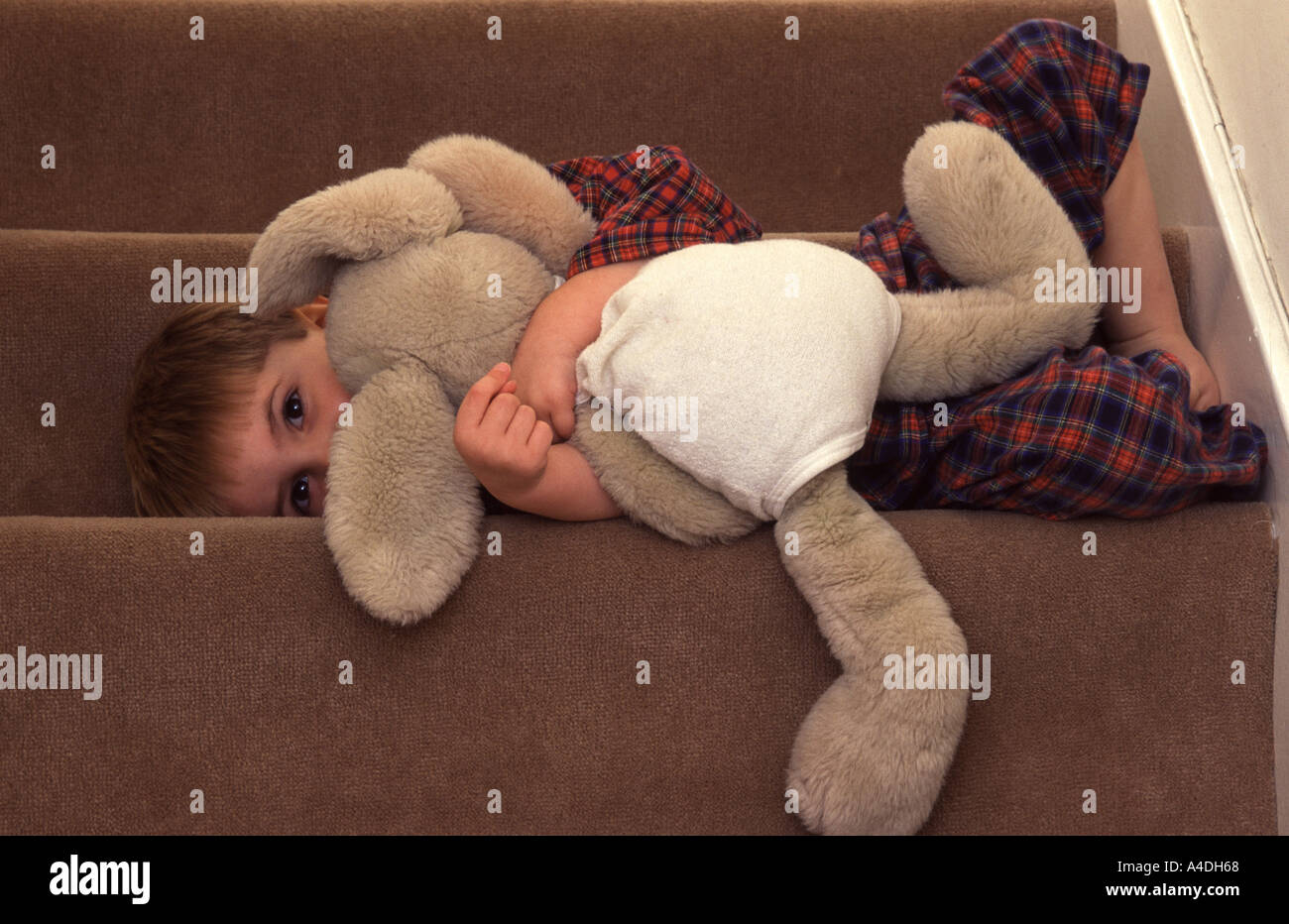 Il Toddler abbracciando un giocattolo morbido e prepararsi per il letto Foto Stock