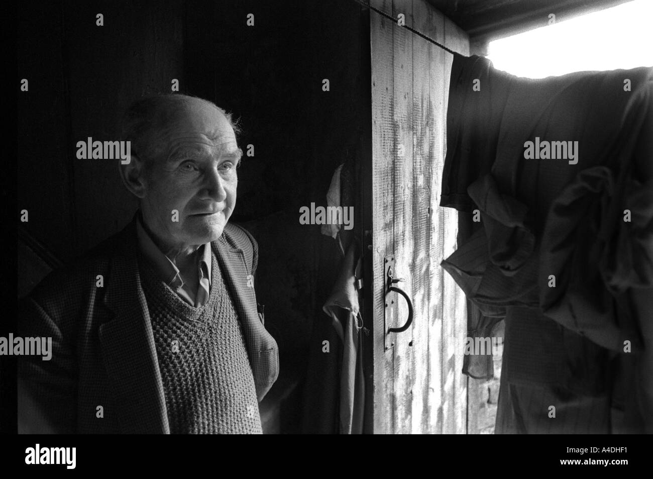 Un anziano uomo in piedi presso la porta per la sua cucina con la sua biancheria appesa sopra la porta. Everton, Liverpool Foto Stock