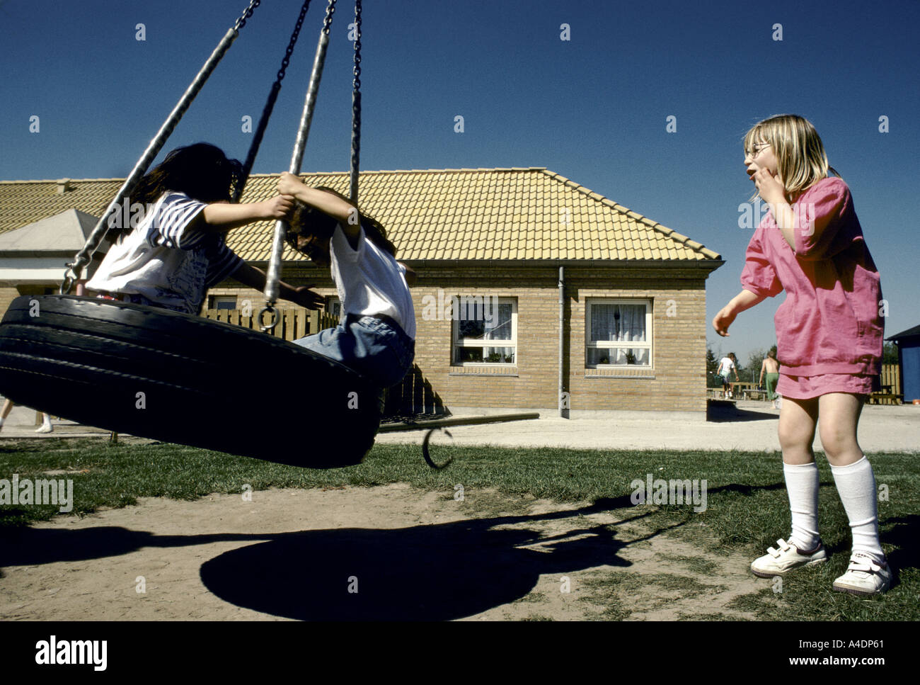 Bambini su un pneumatico in rotazione un open air parco giochi. Arhus, Danimarca Foto Stock