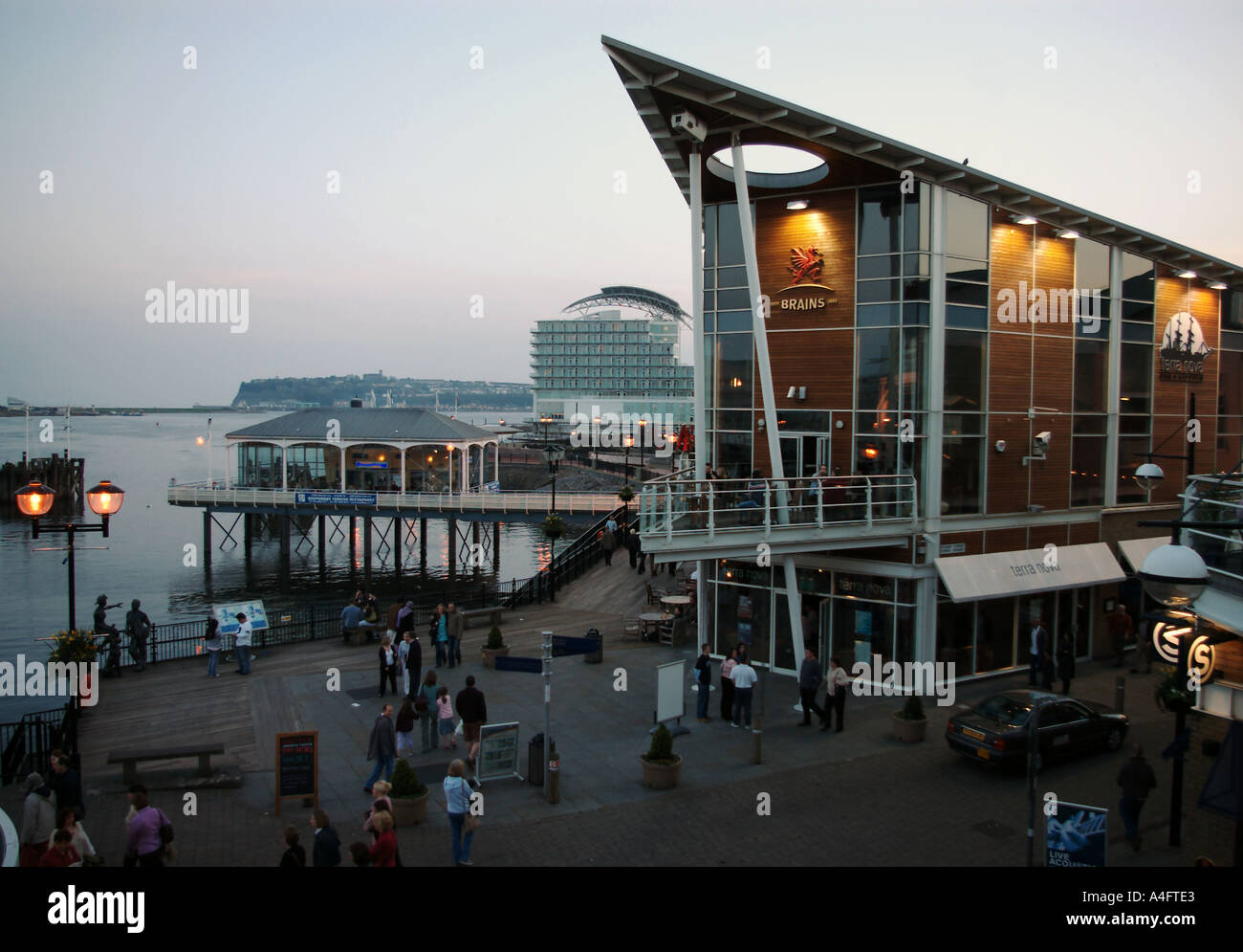 Cardiff Bay promenade bar di Mermaid Quay e Forte Hotel al crepuscolo Foto Stock