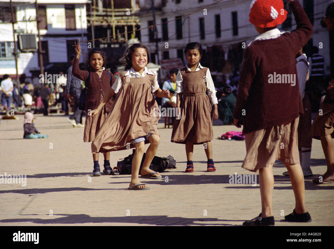 Ragazze in uniforme scolastica saltando il quadrato di Durbar Kathmandu in Nepal Foto Stock