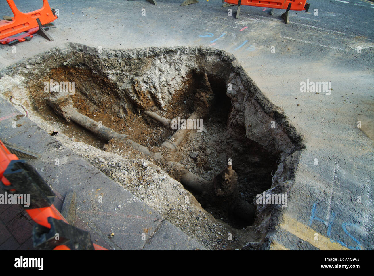 Foro nella strada per la sostituzione dell'invecchiamento della ghisa acqua di rete Foto Stock