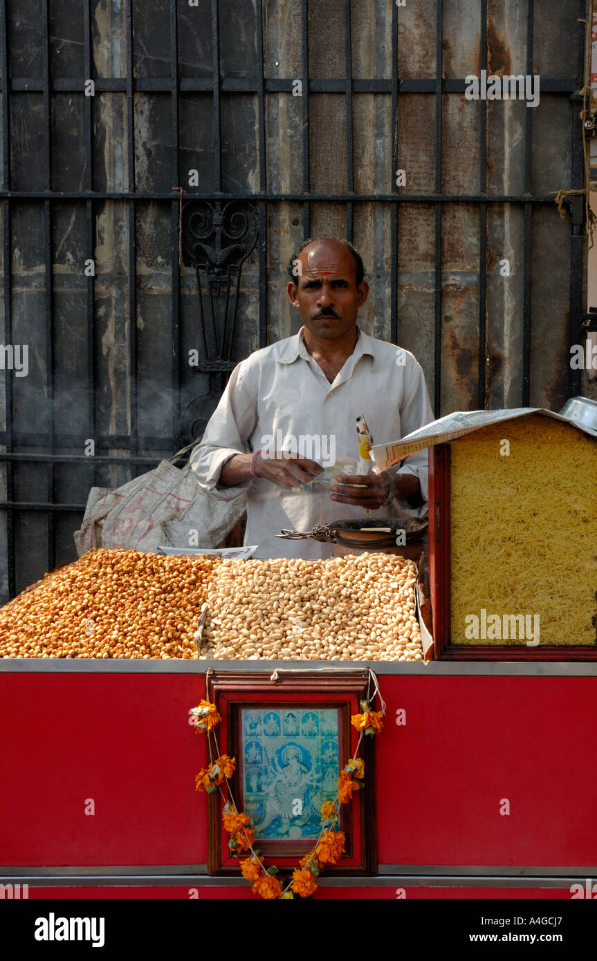 L'uomo vendita di arachidi tostate sulla bancarella di strada che si trovano tipicamente in India Foto Stock