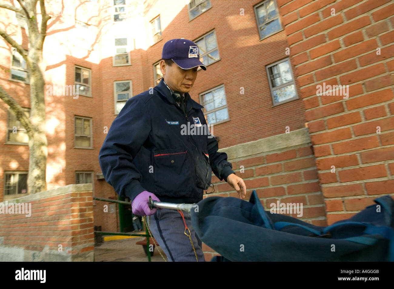 Un postino recapita mail in uptown New York City Stati Uniti d'America novembre 2004 Foto Stock