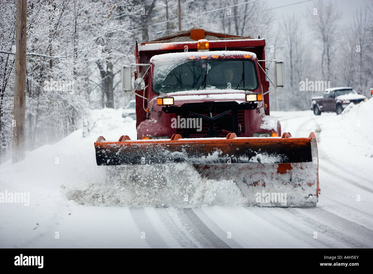 Snow Plough clearing street durante la tempesta di neve Foto Stock
