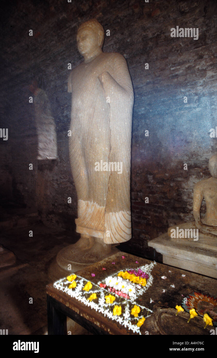 Un misteriosamente incandescenza spirituale illumina un'immagine del Buddha in uno del buio magnifiche rovine di Polonnaruwa nord dello Sri Lanka Foto Stock