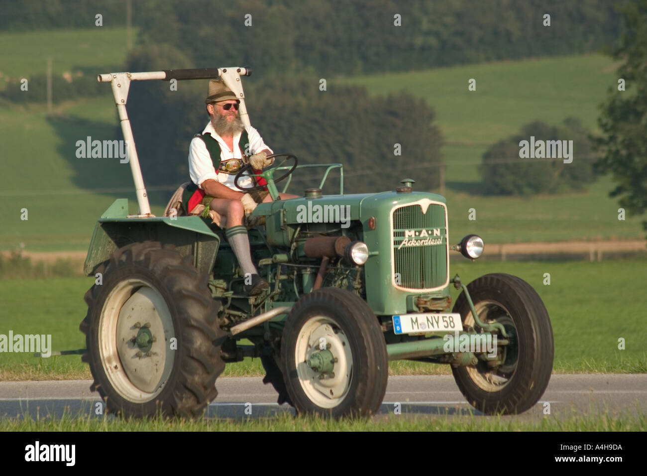 Agricoltore tradizionale su un uomo trattore vicino Dietramszell Baviera Germania Sig. Nr 0017 Foto Stock