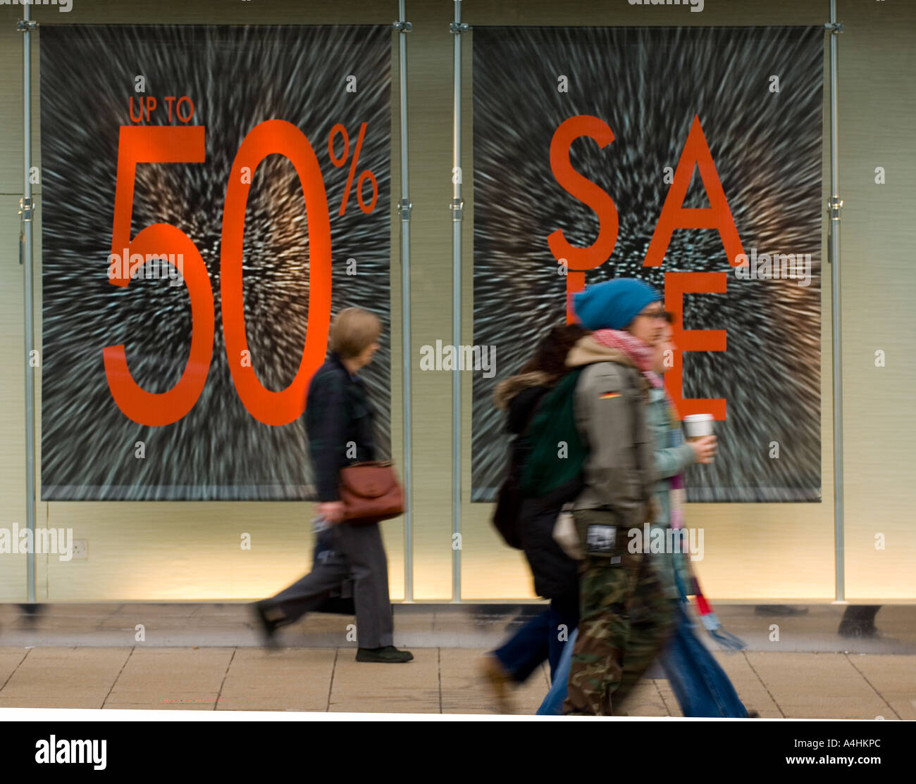 Grandi segni di vendita in vetrina e gli acquirenti su British High Street Foto Stock