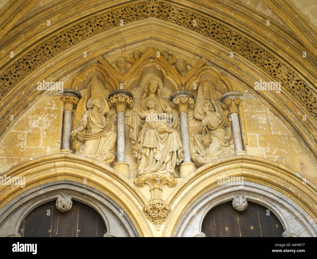 La Cattedrale di Salisbury Wiltshire, Inghilterra Vergine Maria bambino sopra le porte affiancato da angeli Censing fronte ovest Foto Stock