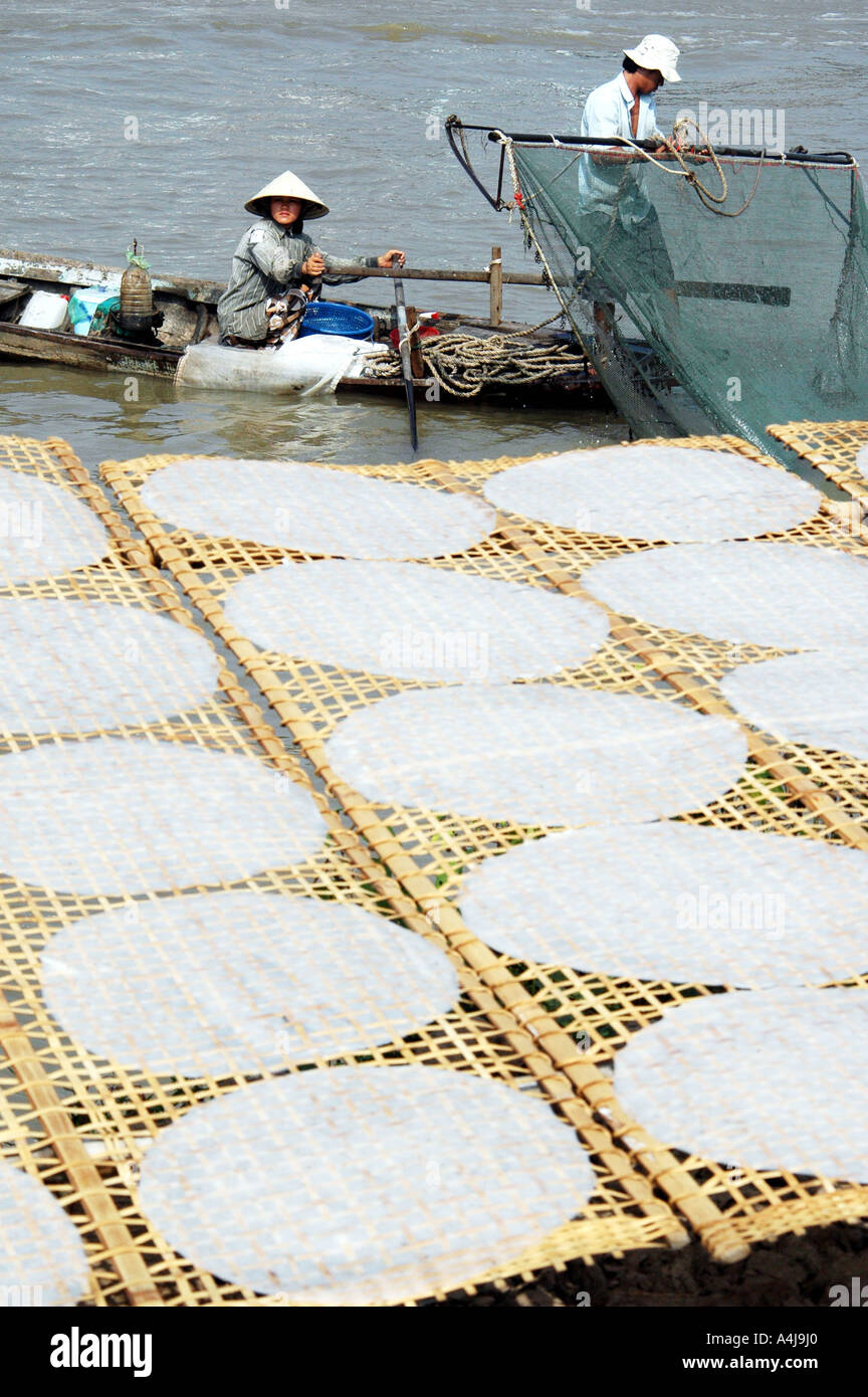 I pescatori con torte di riso di essiccazione al sole Vietnam Foto Stock