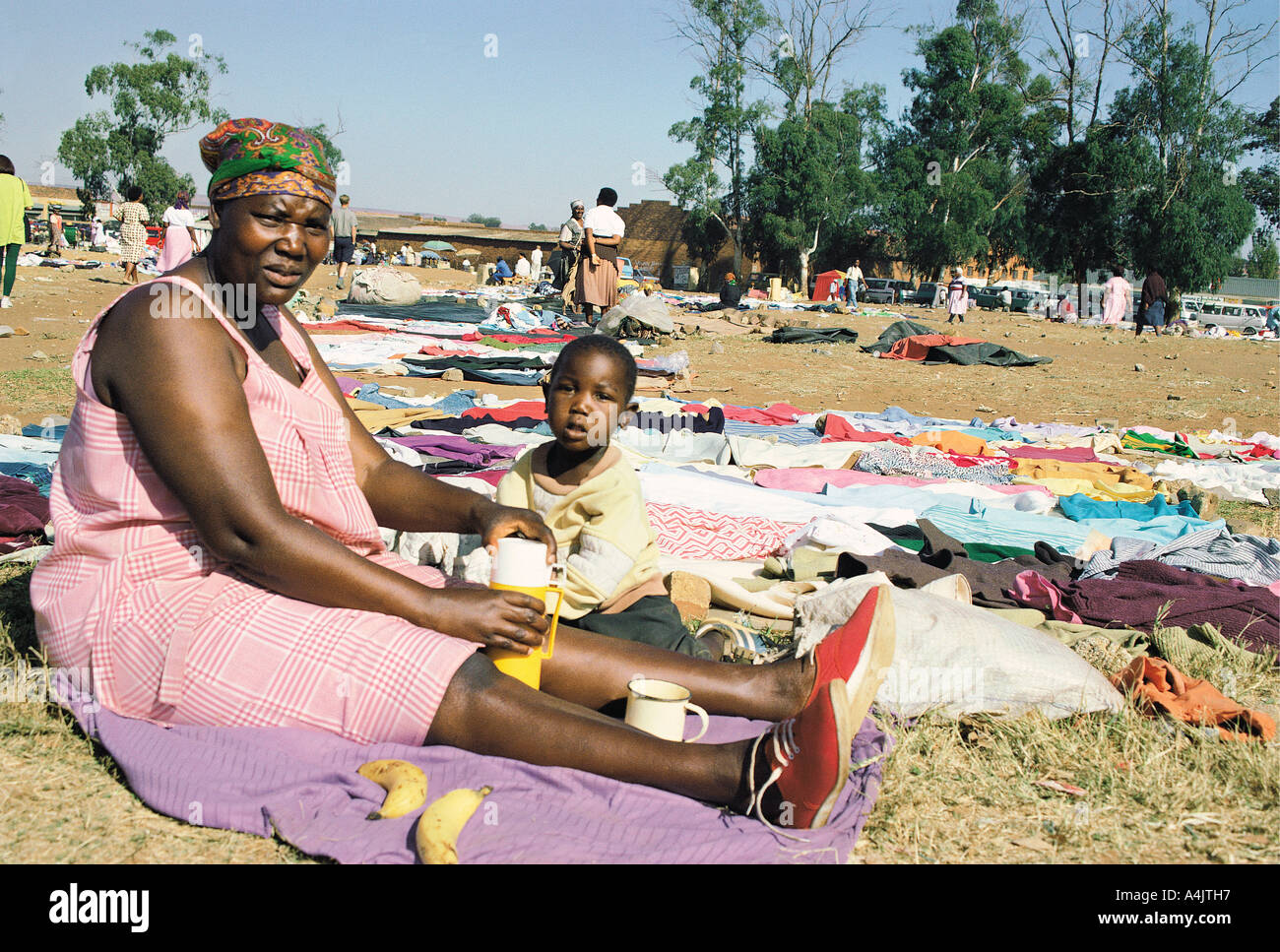 Donna africana e il bambino a fianco della seconda mano vestiti ella è la vendita di Soweto township di Johannesburg in Sud Africa Foto Stock