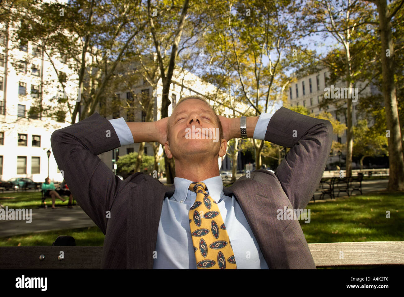 Imprenditore nel parco cercando con le mani sulla testa Foto Stock