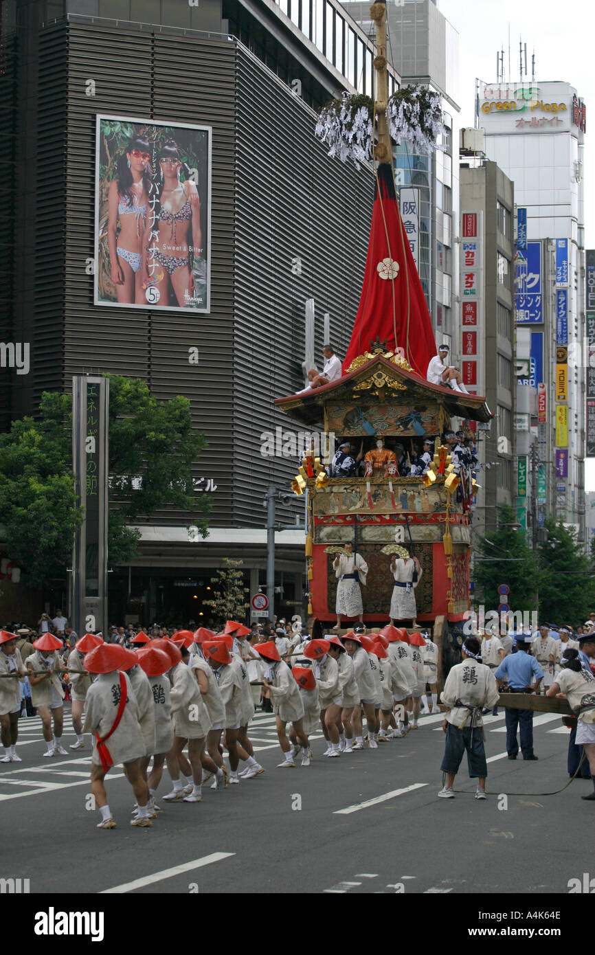 Un antico galleggiante dal Gion Matsuri festival contrasta fortemente con il giorno moderno Giappone durante a Kyoto in Giappone Asia Foto Stock