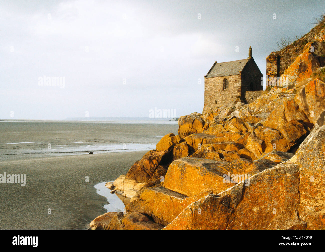 Casa di pietra sulle rocce che si affaccia su Beach Foto Stock