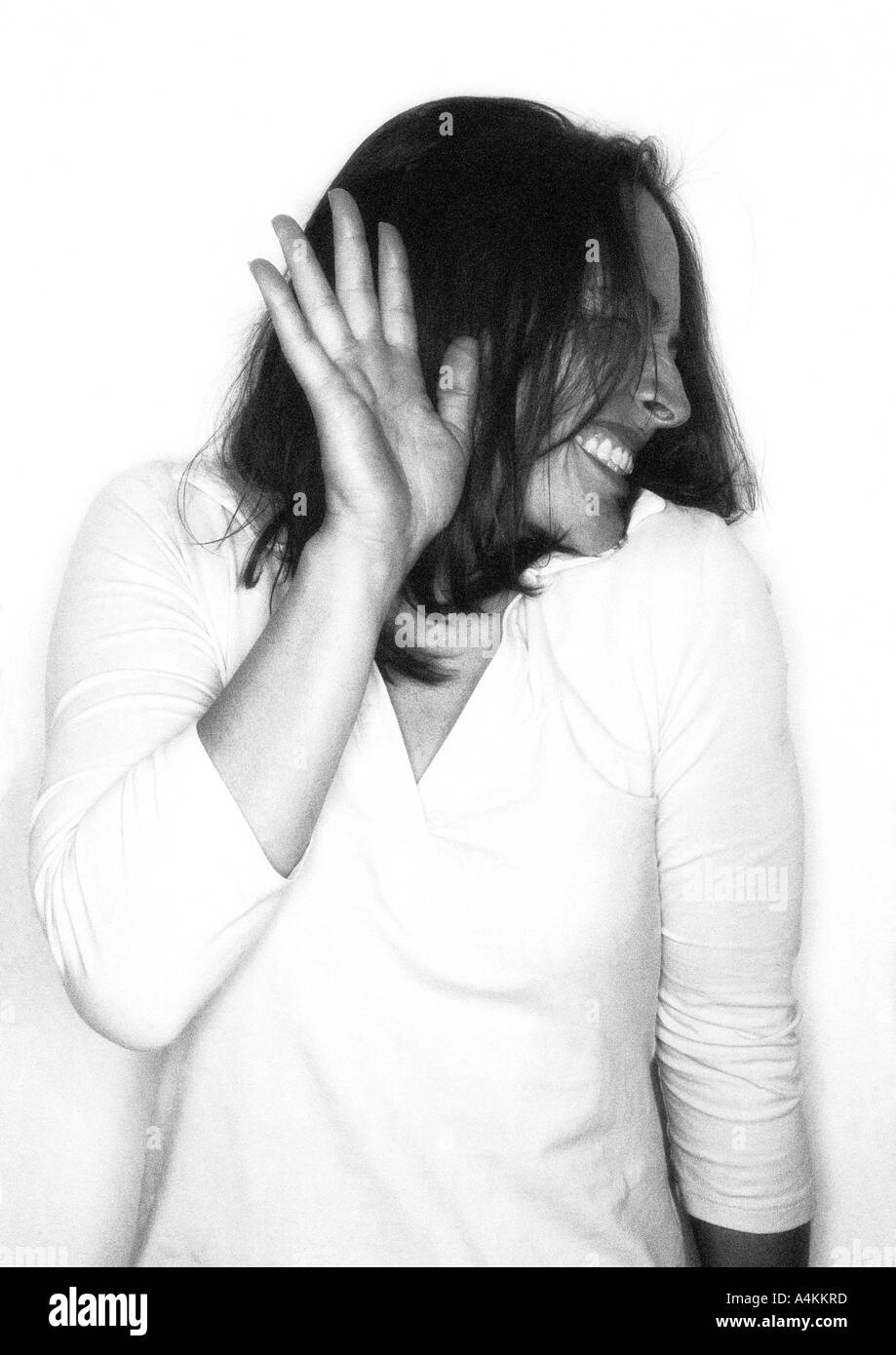 Donna che mantiene fino a mano girando il viso lontano dalla fotocamera, ritratto Foto Stock