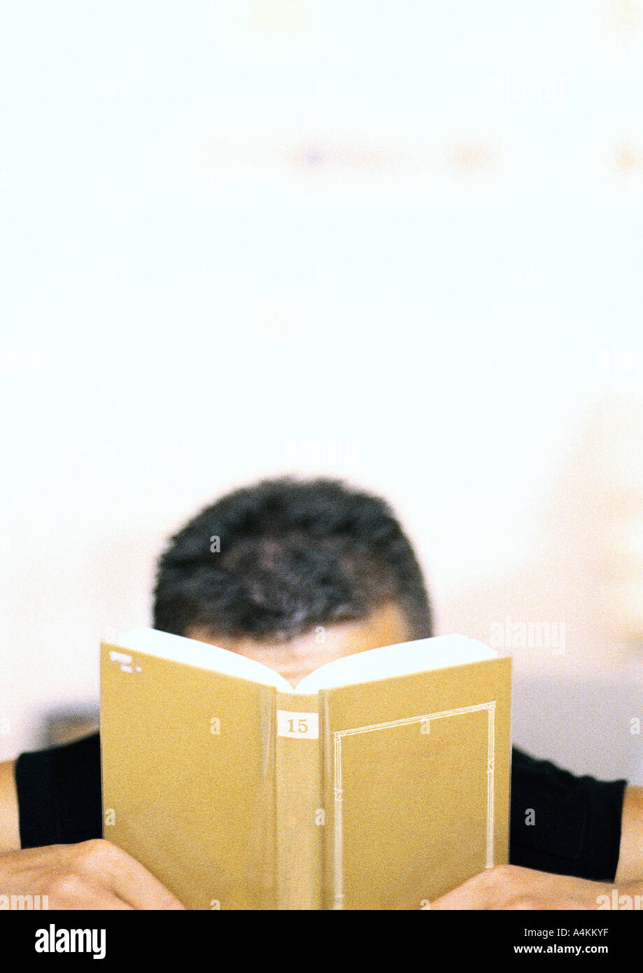 Uomo libro di contenimento nella parte anteriore del viso Foto Stock