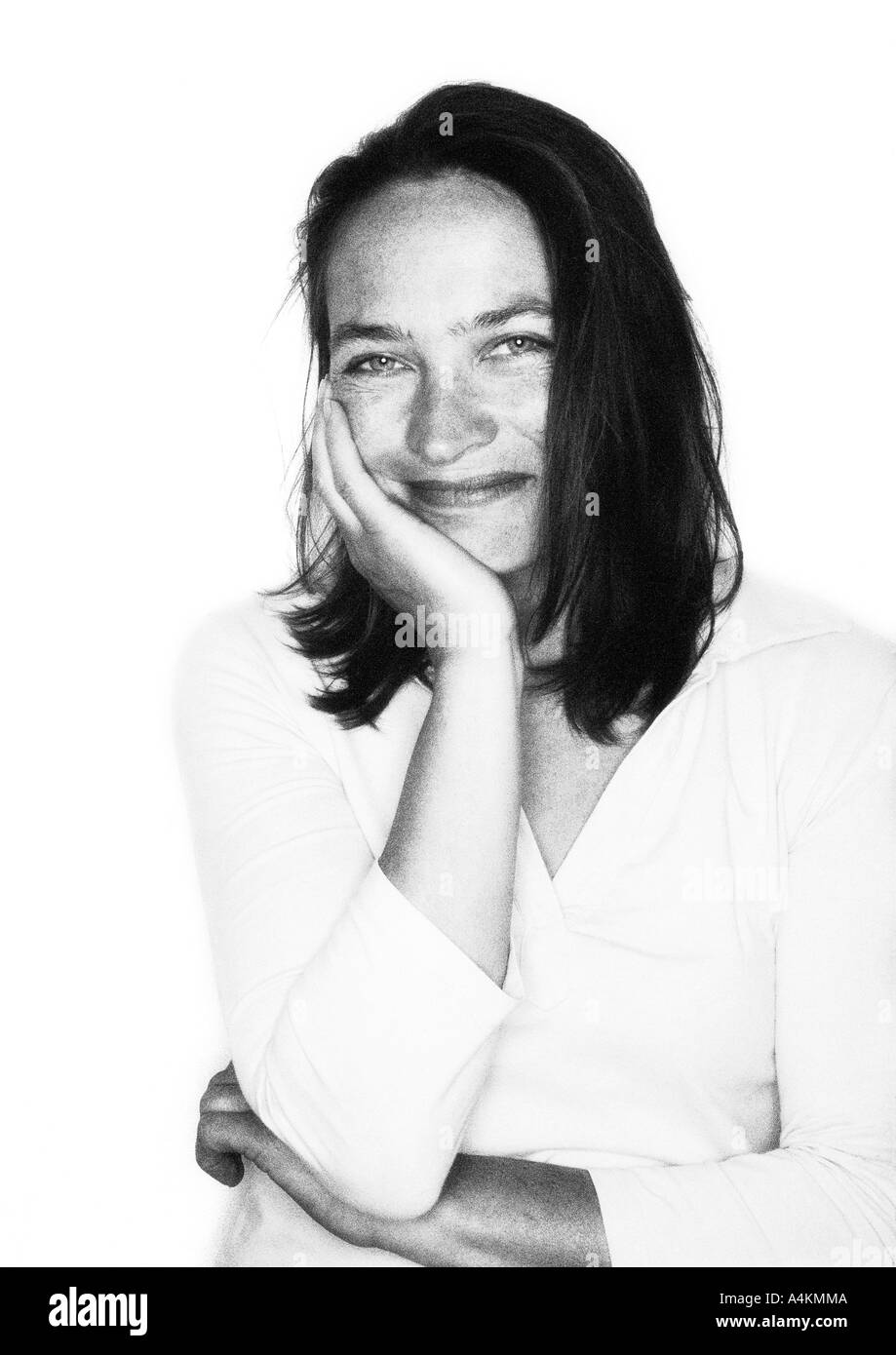 Donna sorridente, mano sulla guancia, portait b&w. Foto Stock