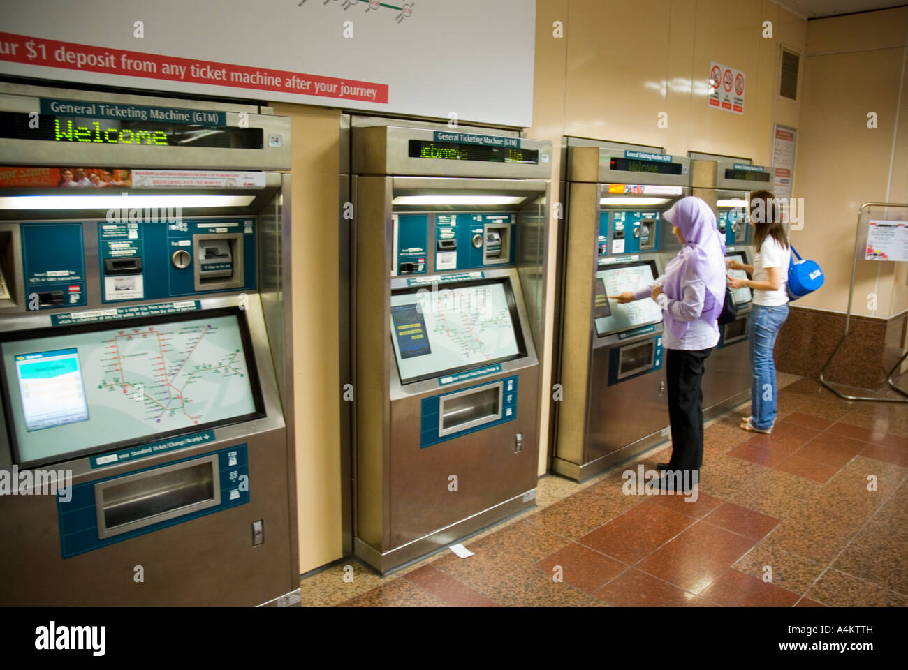 I passeggeri che utilizzano le biglietterie automatiche per Singapore urbana sistema di treno Foto Stock