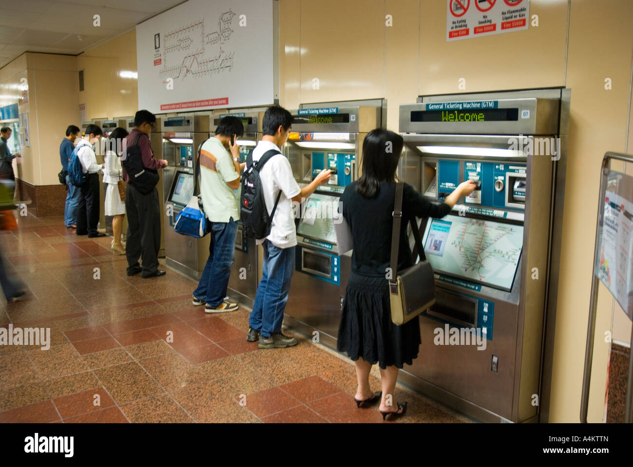 I passeggeri che utilizzano le biglietterie automatiche per Singapore urbana sistema di treno Foto Stock