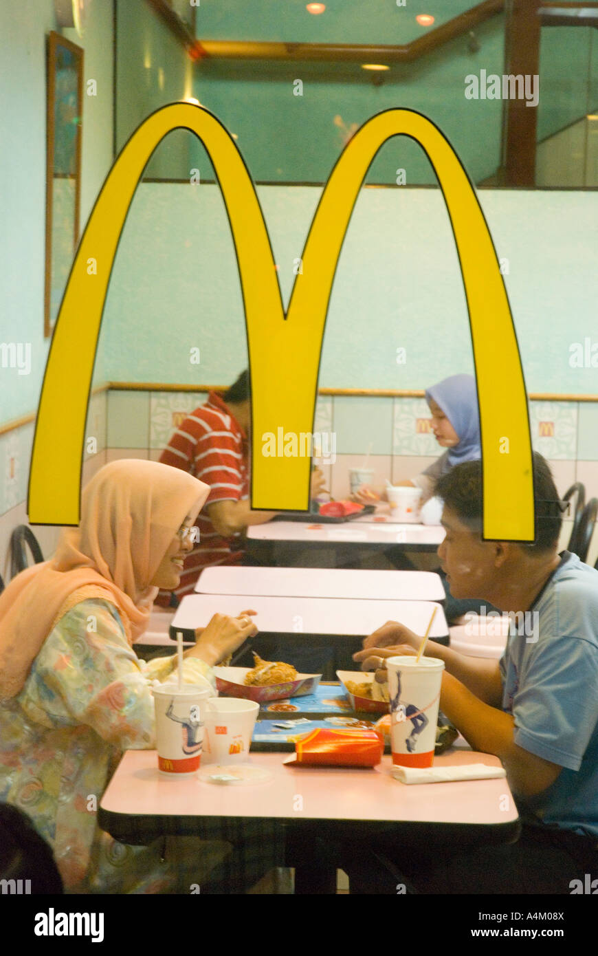 Un giovane musulmano godetevi un hamburger in un halal ristorante McDonalds a Kuching Sarawak Foto Stock