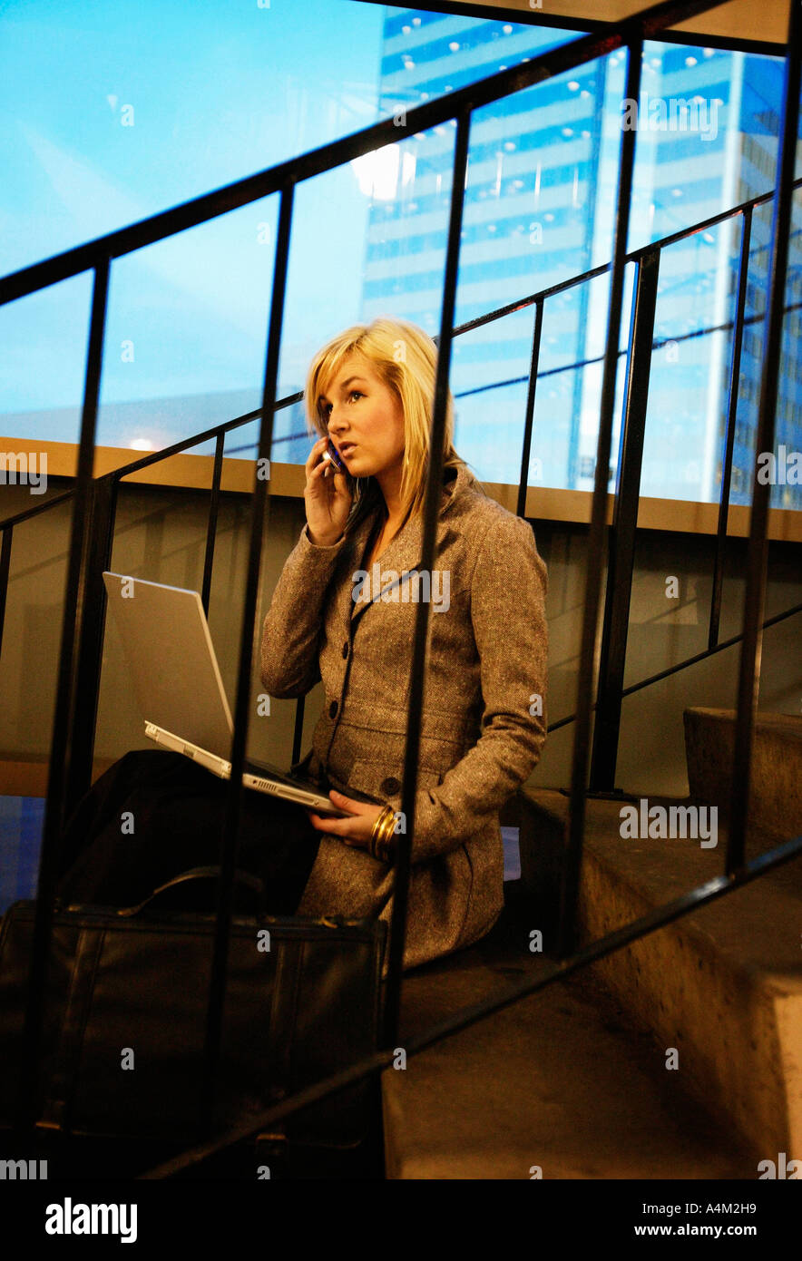 Donna al telefono cellulare e computer lap top Foto Stock