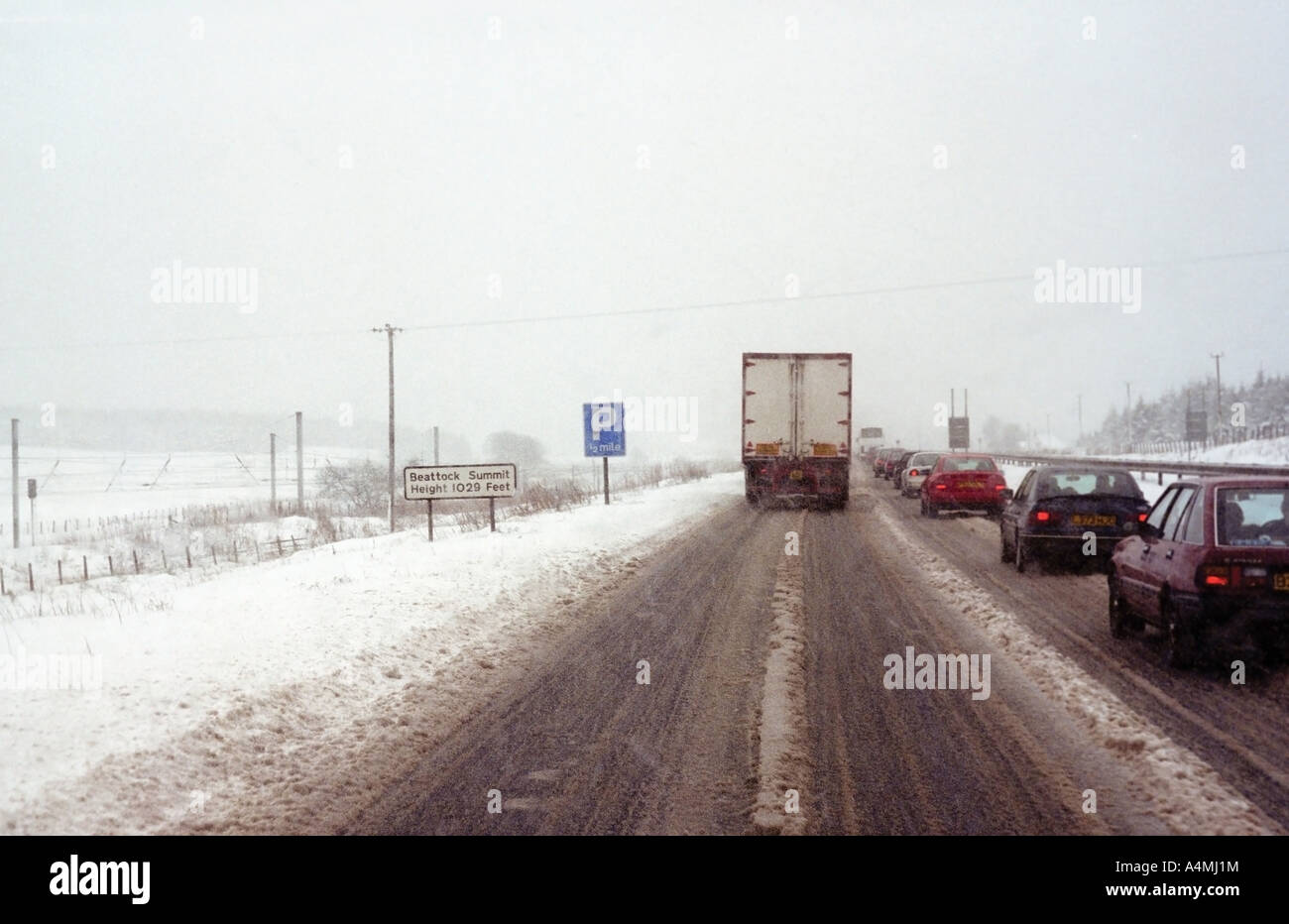 Movimento lento del traffico su strade coperte di neve A74 strada al Vertice Beattock, Scozia. Foto Stock