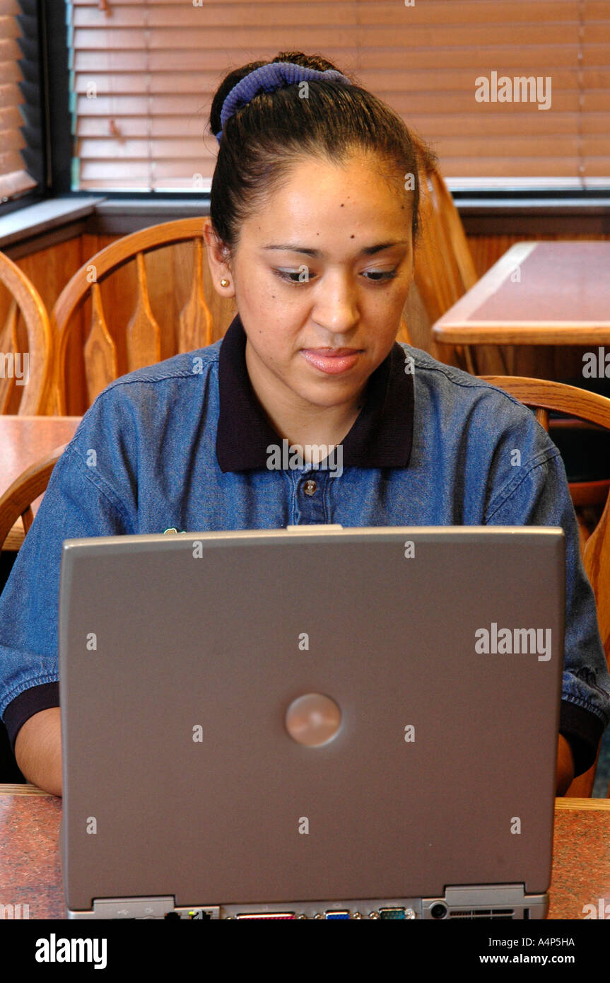 Donna ispanica a lavorare con un computer portatile Foto Stock