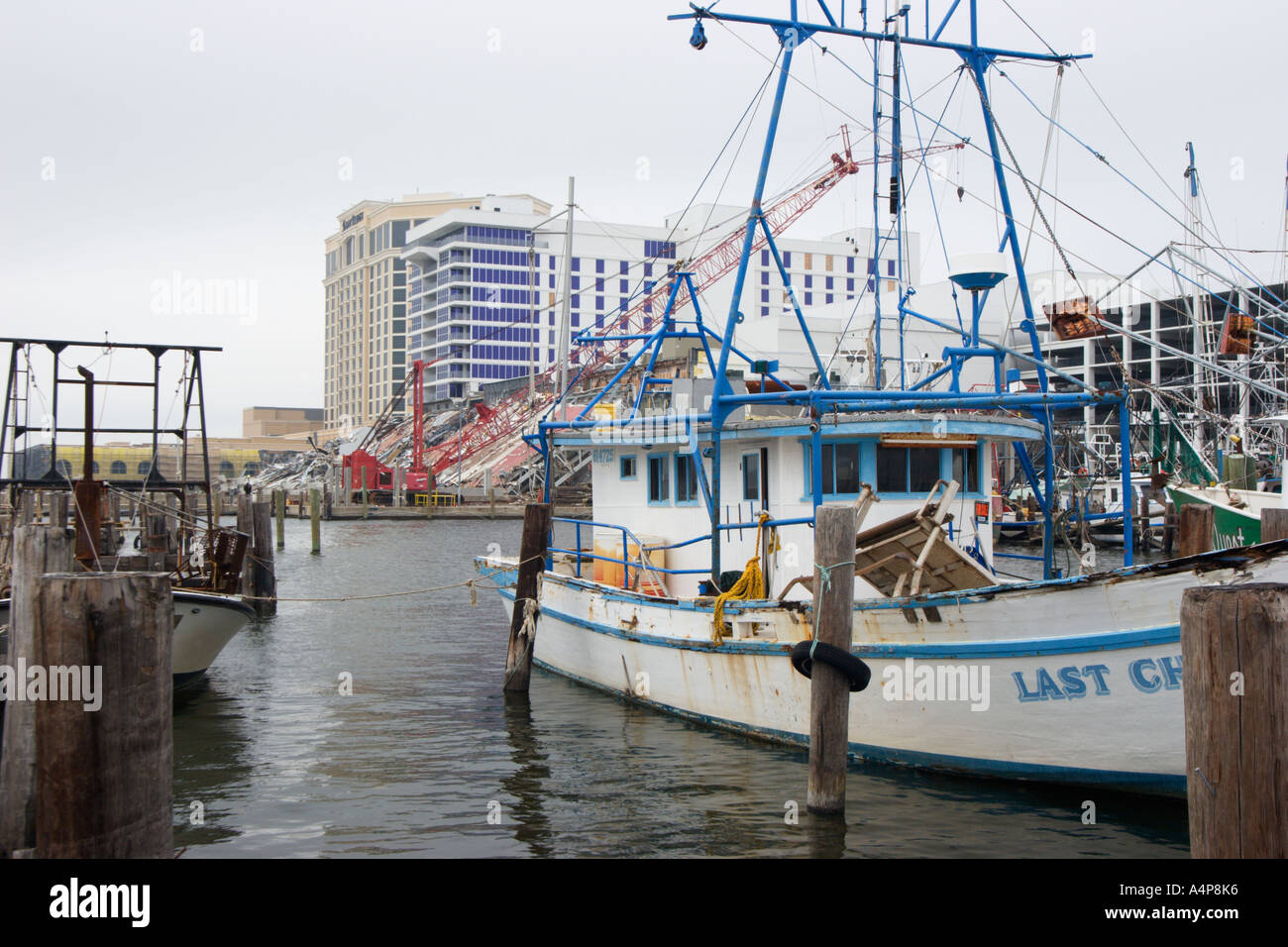 Barche di gamberi nel porto di pesca commerciale con casinò demolito sullo sfondo a Biloxi Mississippi USA sei mesi dopo l'uragano Katrina distrusse la costa del Golfo del Mississippi Foto Stock