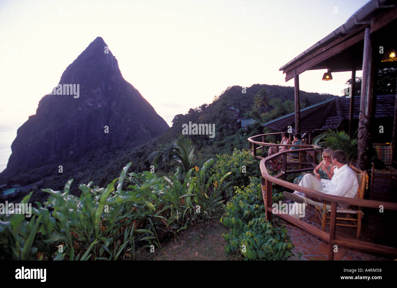 La gente seduta al bar balcone del Ladrea resort si affaccia sul Pitons montagne vulcaniche St Lucia Foto Stock