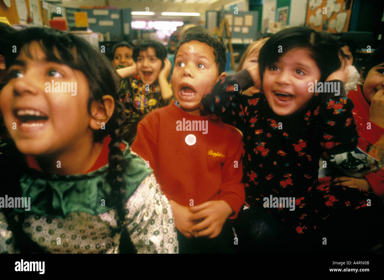 Ragazzi e ragazze musulmane scuola primaria, gridare e urlare durante la lettura del libro in Bradford West Yorkshire Regno Unito Foto Stock