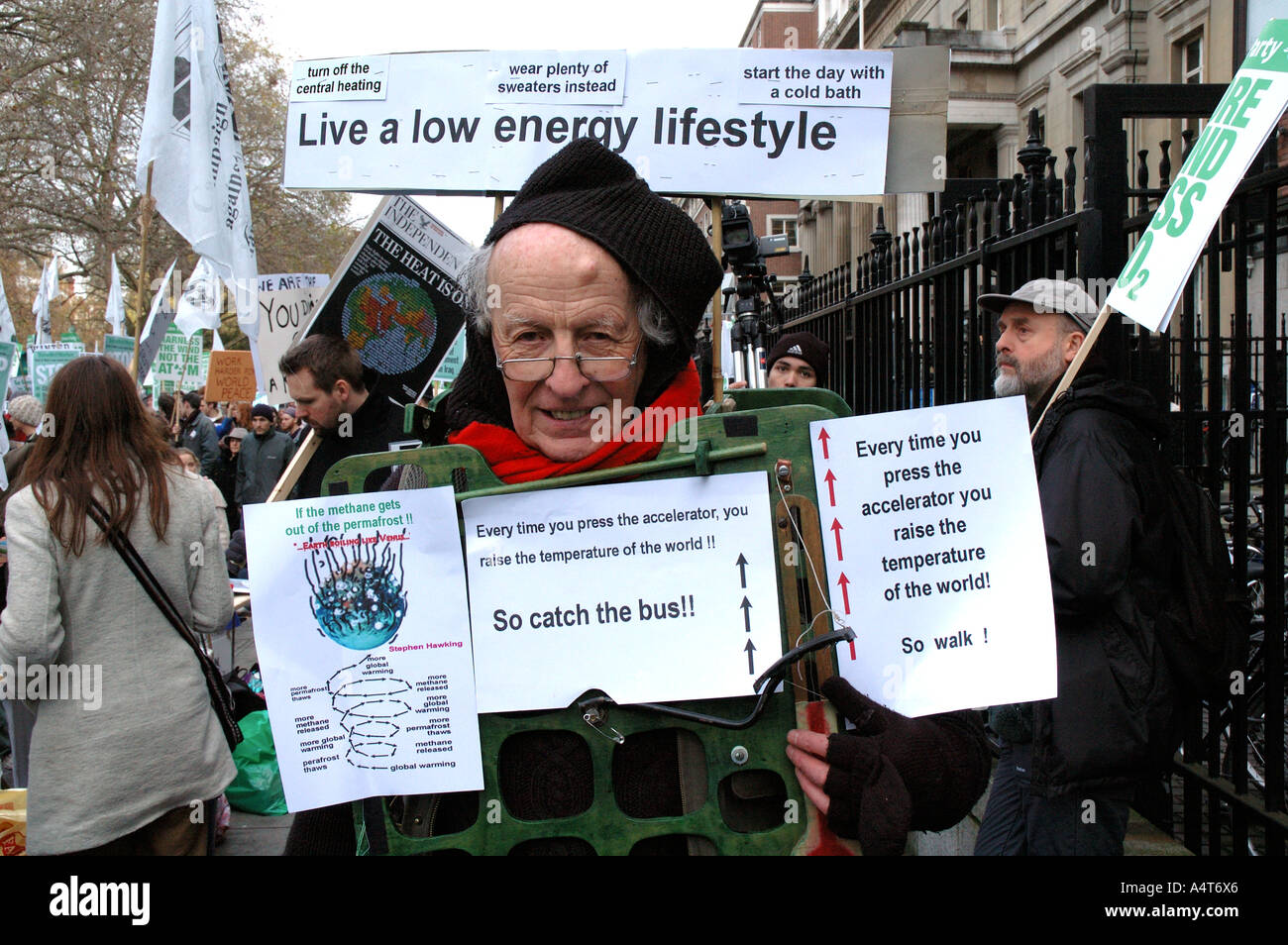 Uomo con cartelli al Cambiamento Climatico protesta ambientale attraverso il centro di Londra. Foto Stock