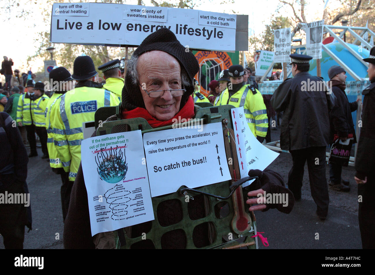 Uomo con cartelli al Cambiamento Climatico protesta ambientale attraverso il centro di Londra. Foto Stock