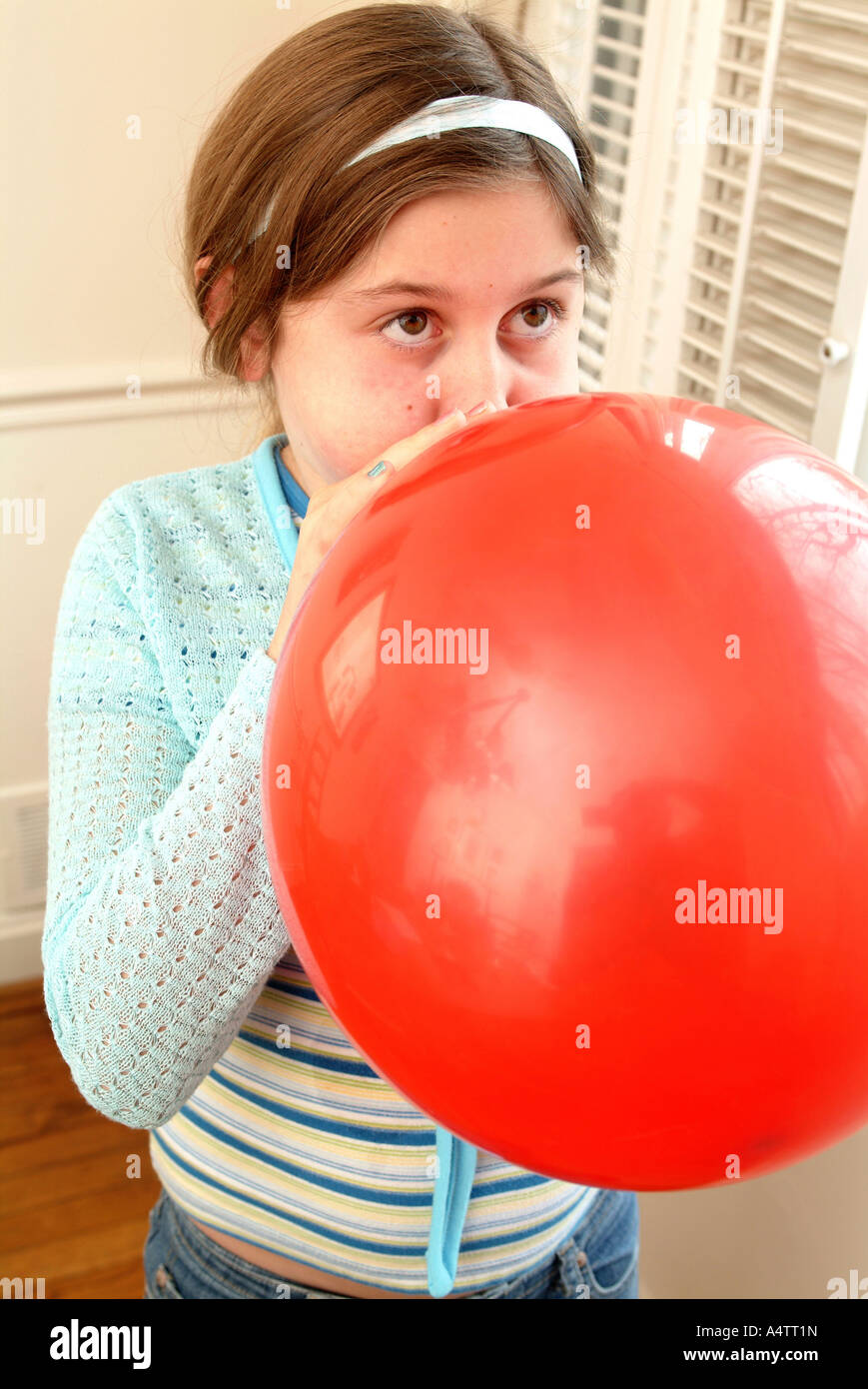 Signor una ragazza utilizza il suo respiro per far saltare in aria un palloncino di grandi dimensioni Foto Stock