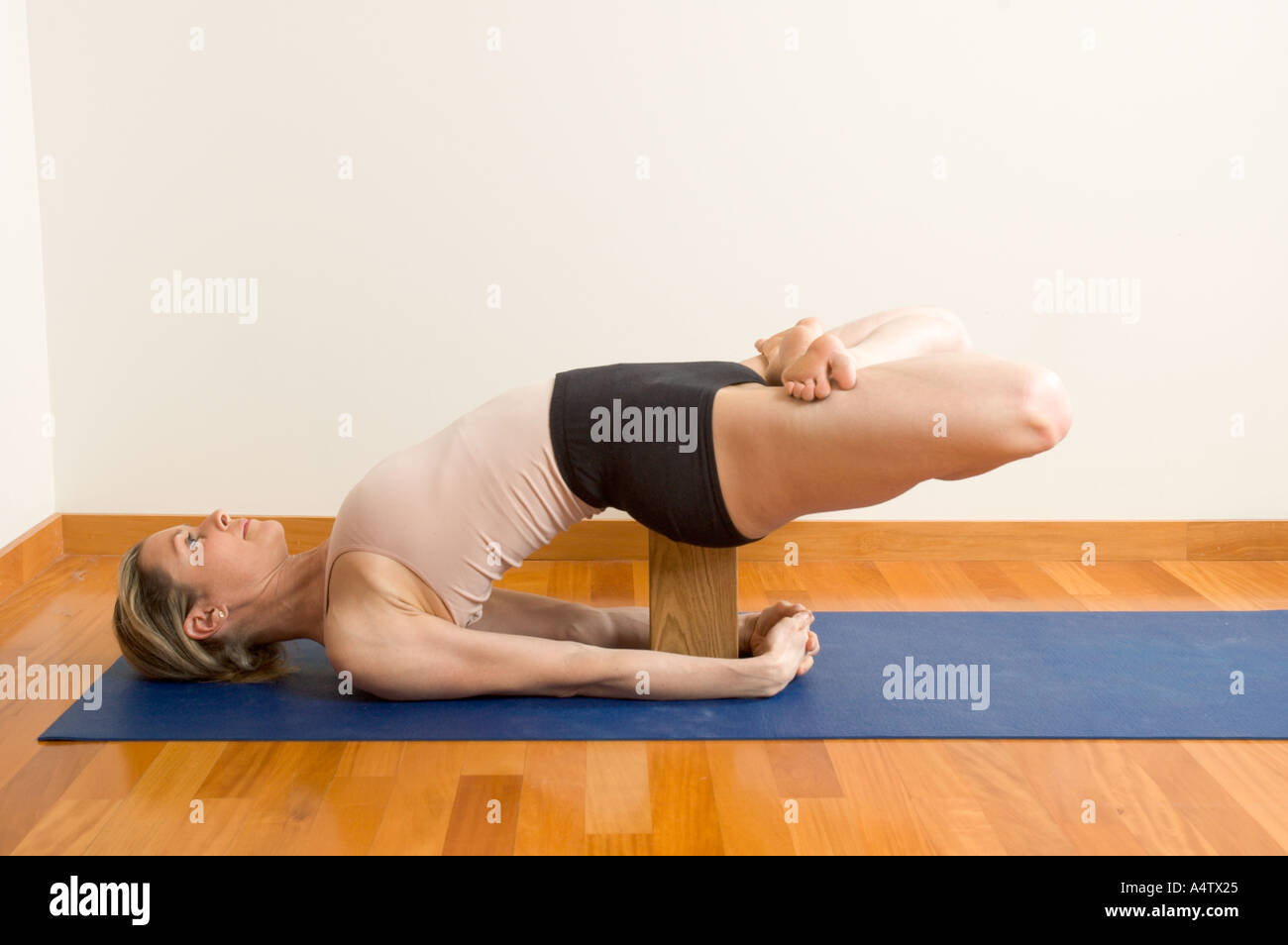 Una donna pratica indietro piegatura posture yoga Iyengar Yoga style Foto Stock