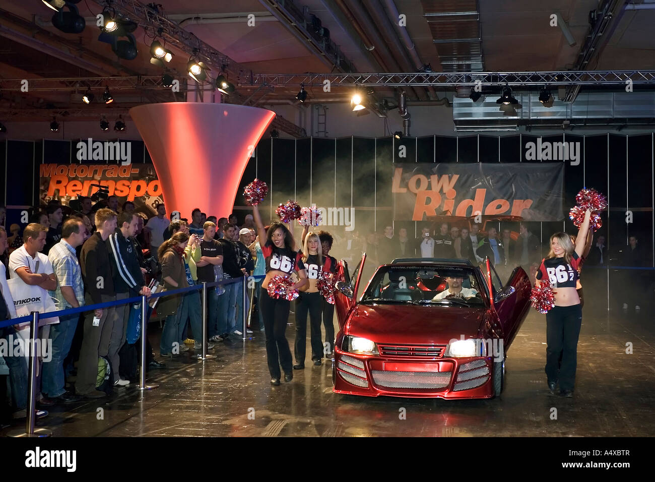 Cheerleader accompagnare una show car a essen motor show, NRW, Germania Foto Stock