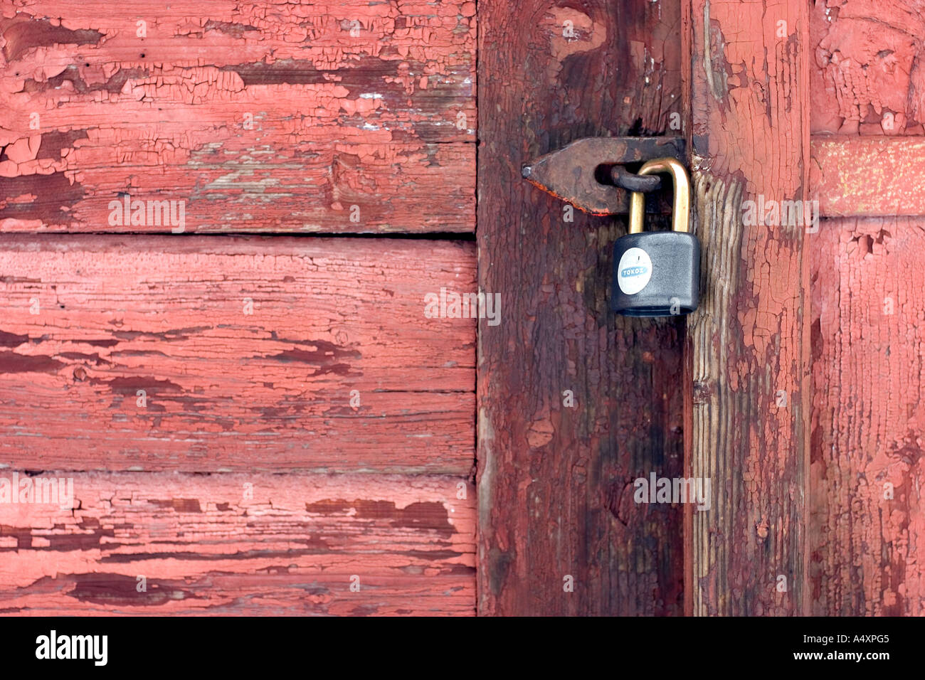 Lucchetto rosso sulla porta di legno Foto Stock