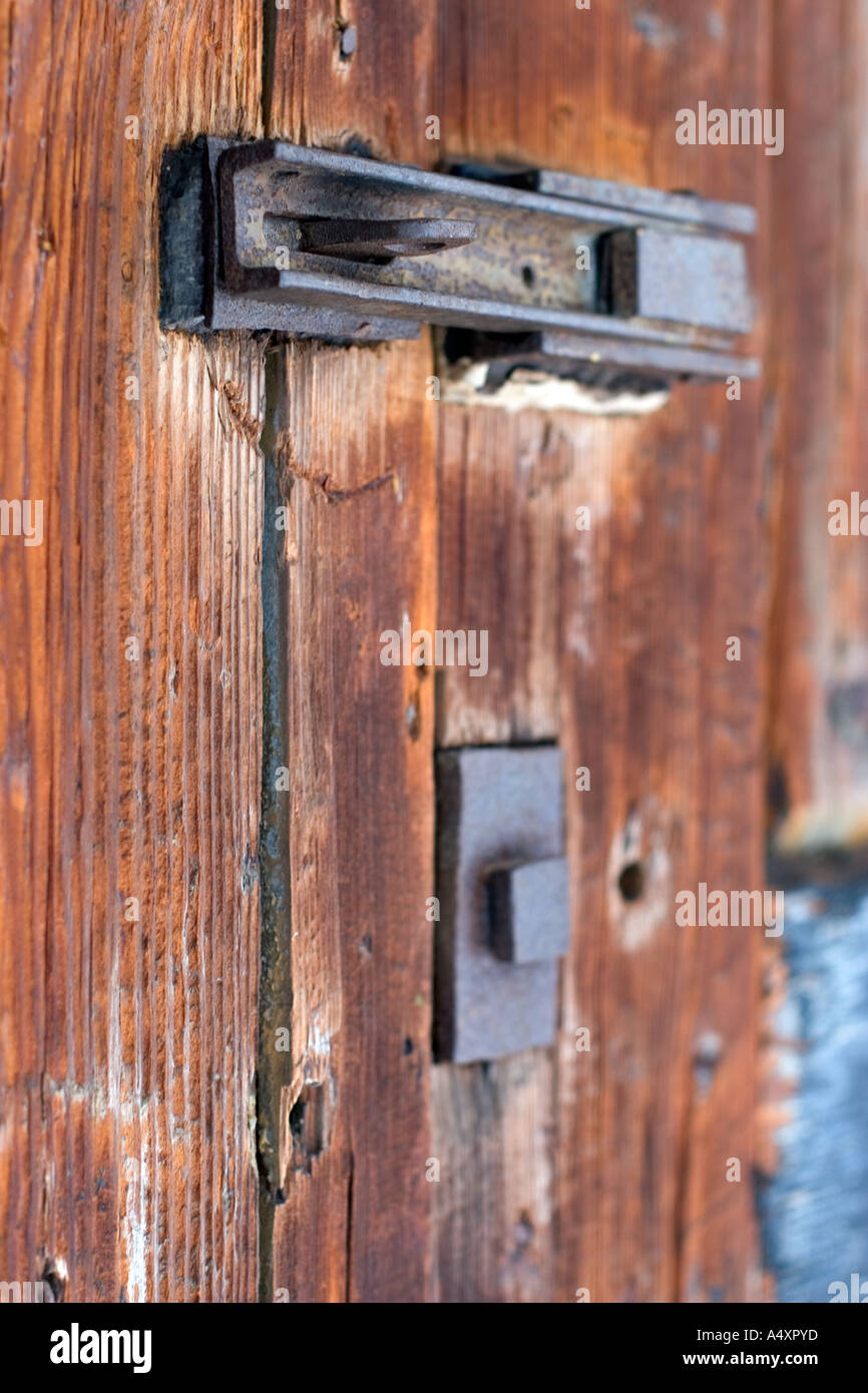Weathered e arrugginita fermo su una vecchia porta di legno Foto Stock