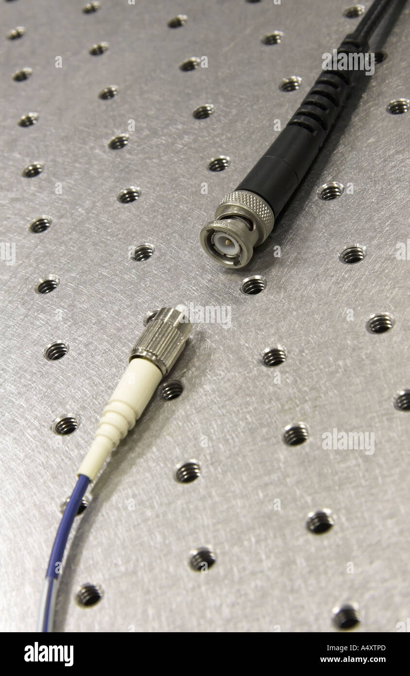 Incompatibili a fibra ottica e cavi elettrici su un tavolo ottico Foto Stock