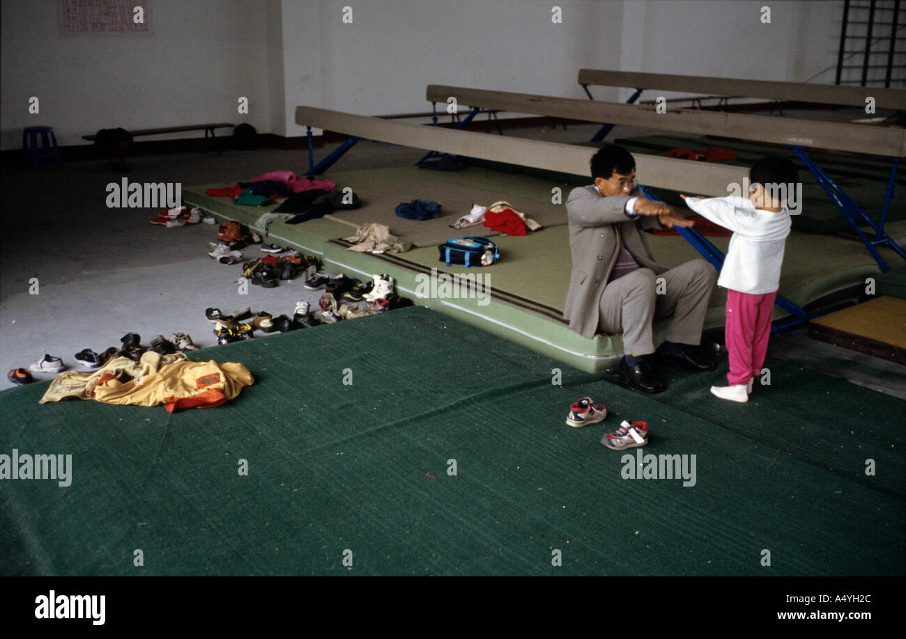 Un padre incarica la sua figlia che pratica la ginnastica all'Li Xiaoshuang ginnastica School di Xiantao di Hubei Cina Foto Stock