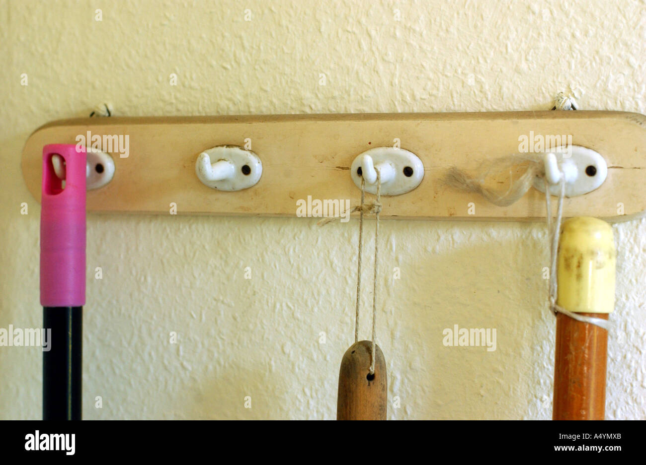 Le presenze nella casa dei genitori: dettaglio e memorie. Broomsticks appendere su volumi sul vecchio confine a gancio Foto Stock