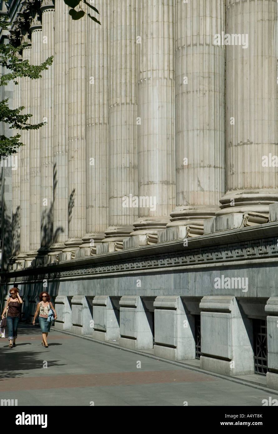 Due donne a piedi lungo la Gran Via nel passato di sole colonne ornate di bank building, Bilbao, Paesi Baschi. Foto Stock