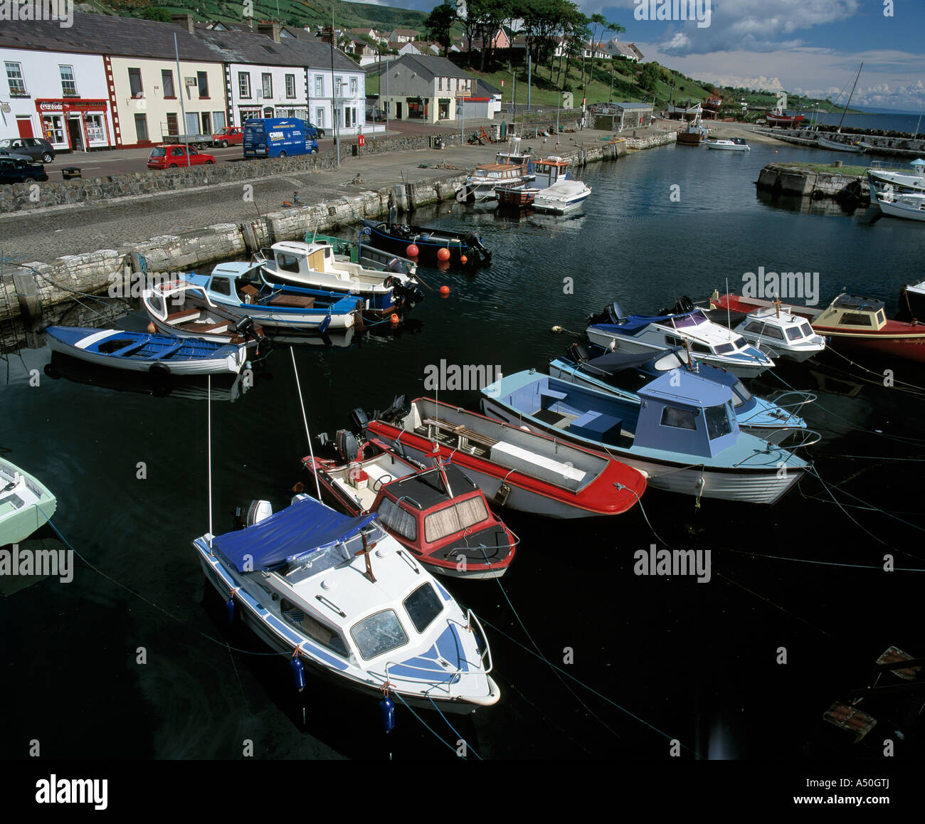 Barche da diporto legato in un riparo villaggio costiero situato sulla costa di Antrim Foto Stock