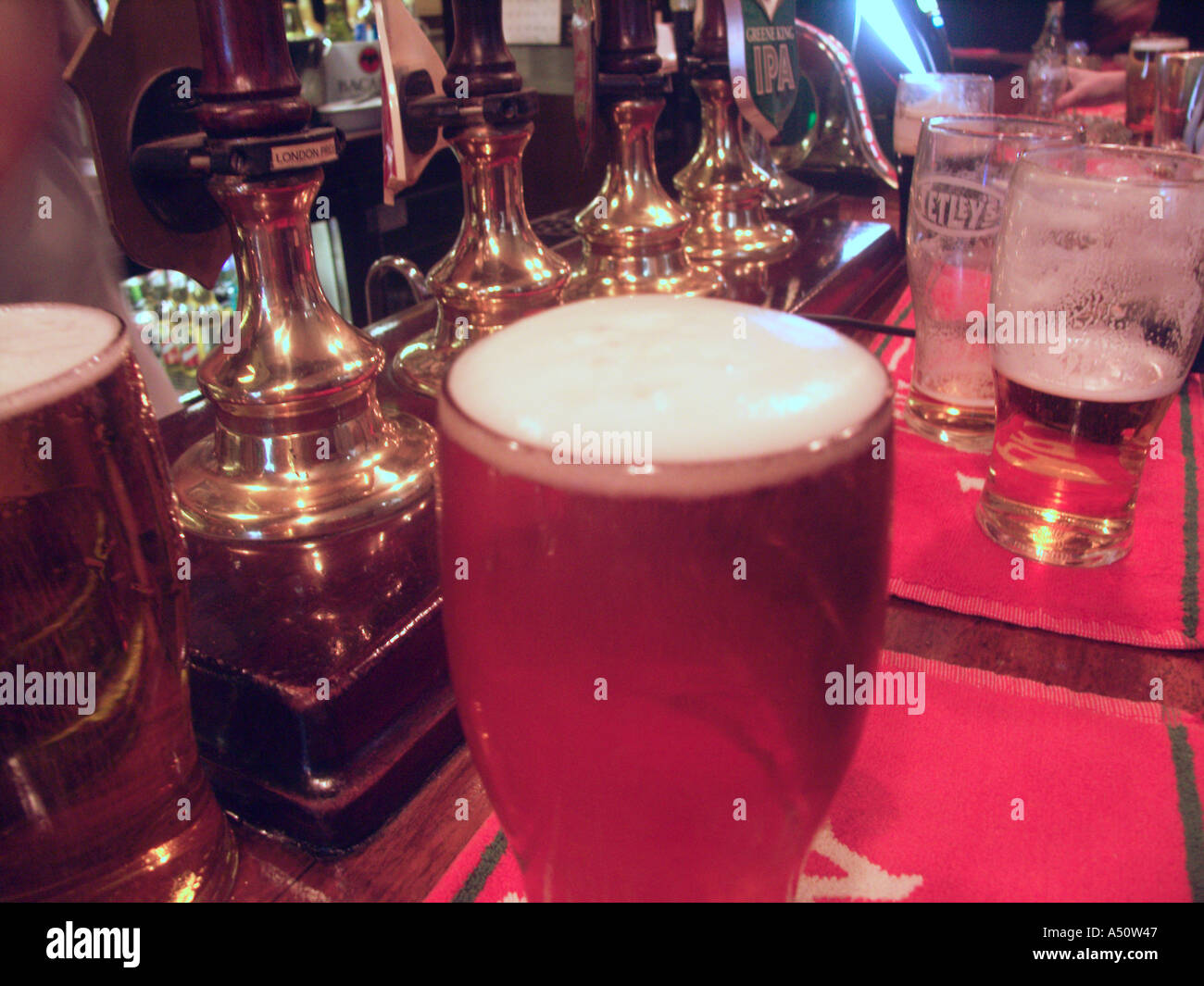 Pinte di birra sul bar pub di Londra Inghilterra interni Foto Stock