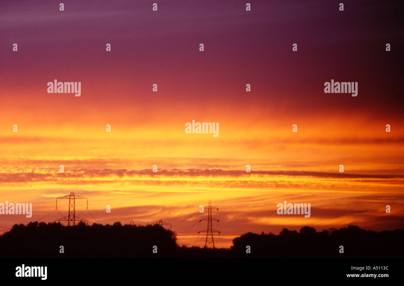 Sun sunrise tramonto groyn notte cirrostratos notturna mattina nuvole arial antenna cavi montante cavo pilone elettricità surrey Foto Stock